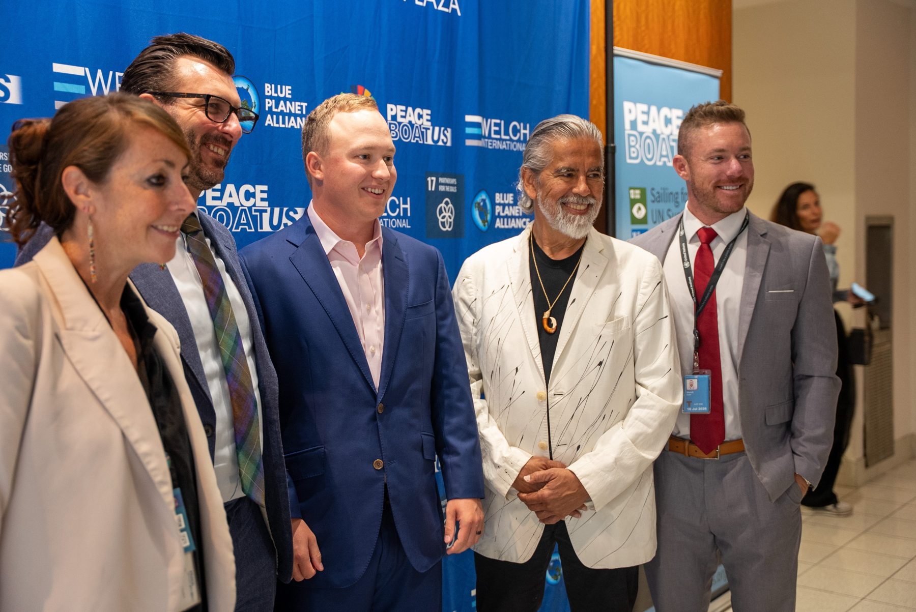Partners at a press wall featuring Welch International, Peace Boat US, and Blue Planet Alliance